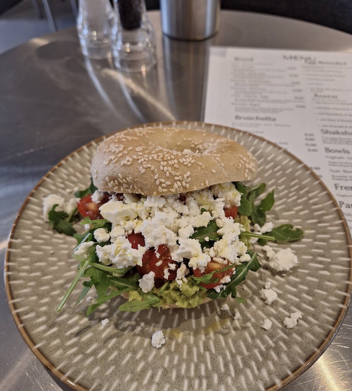Sesame bagel with avocado, tomato and feta